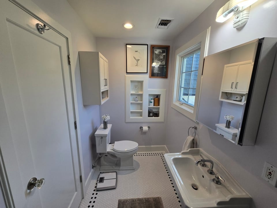 Bathroom remodel in Sacramento, CA featuring built in storage, pedestal sink and small format tile