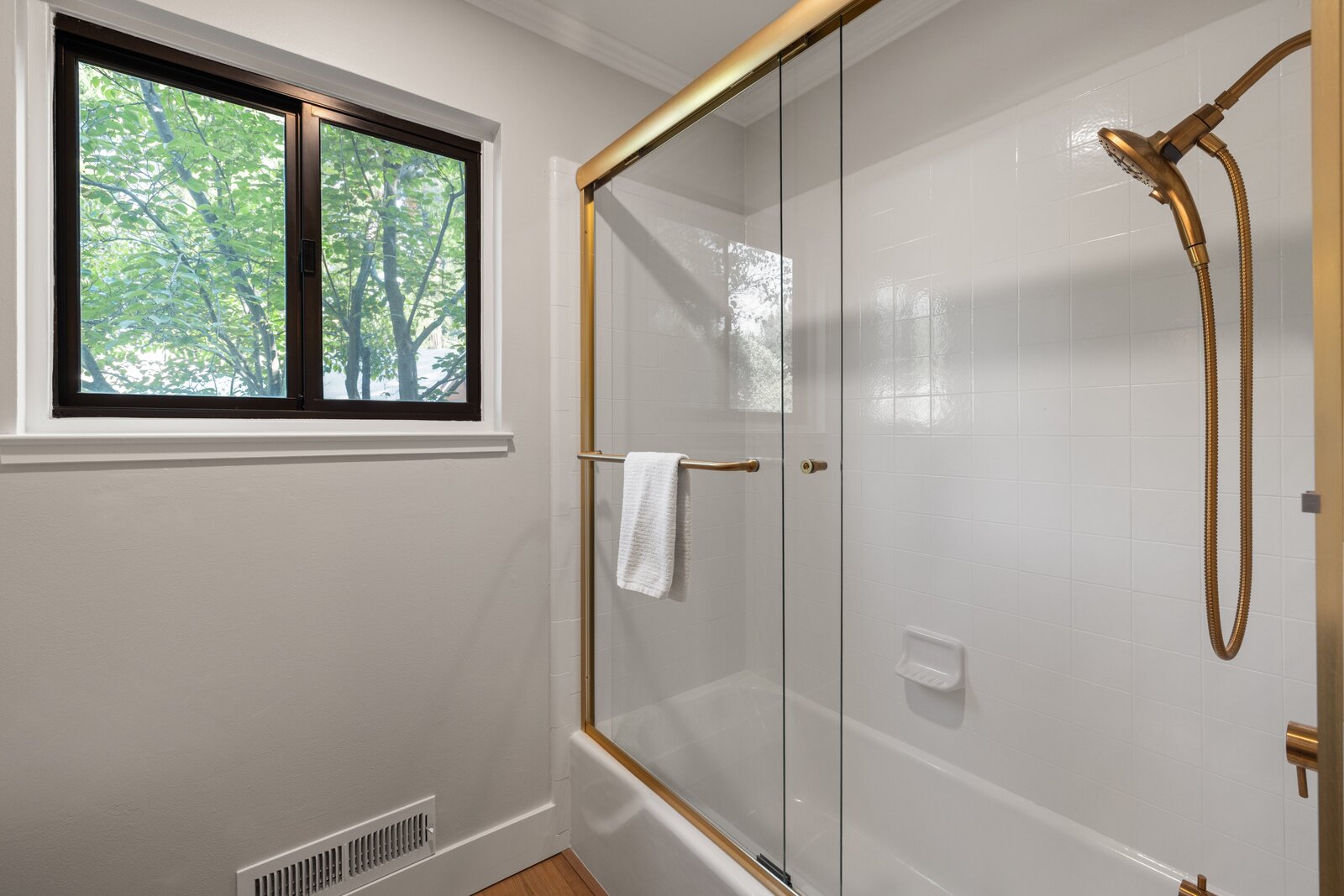 Bathroom remodel in Sacramento, CA with glass shower door and brass hardware