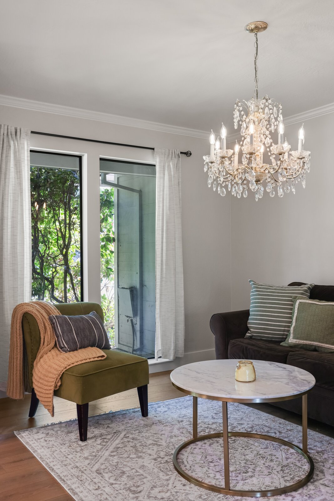 Cozy Sacramento area living room with crystal chandelier and green accent chair