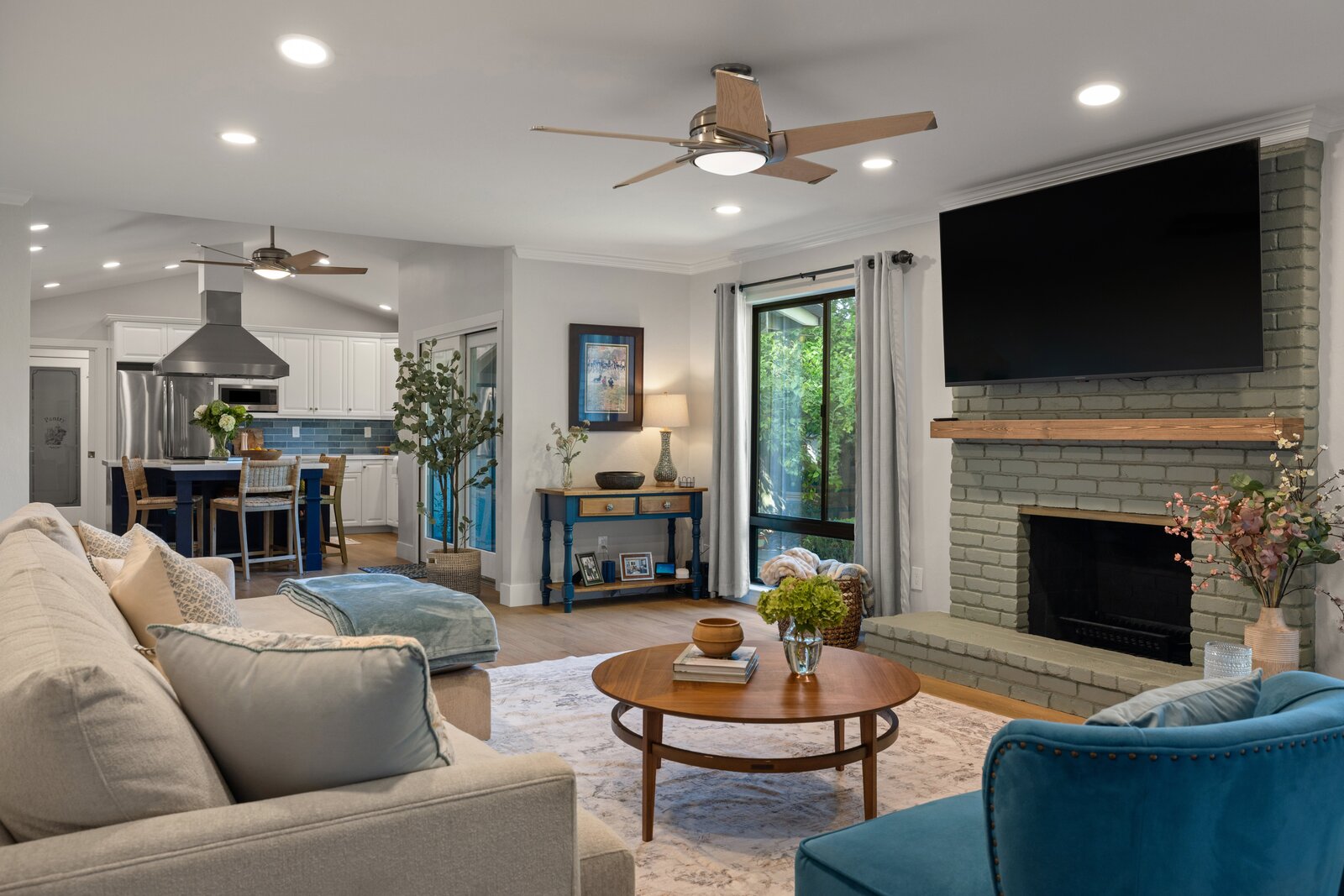 Cozy living room remodel in Sacramento, CA with painted brick fireplace and mounted TV