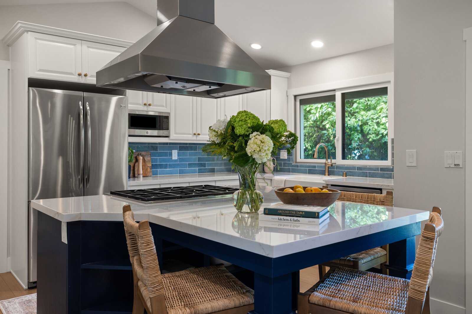 Kitchen island remodel in Sacramento, CA with woven counter stools and stainless range hood