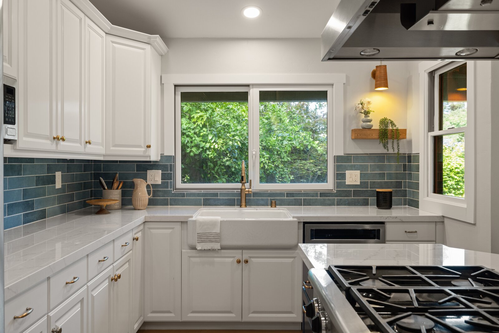 Kitchen remodel in Sacramento, CA with blue subway tile backsplash, farmhouse sink, and gold fixtures