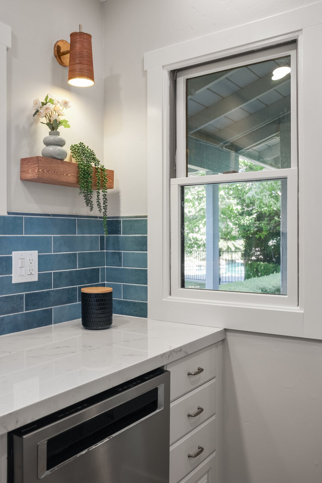 Kitchen remodel in Sacramento, CA with blue subway tile, wood shelf, and wine fridge