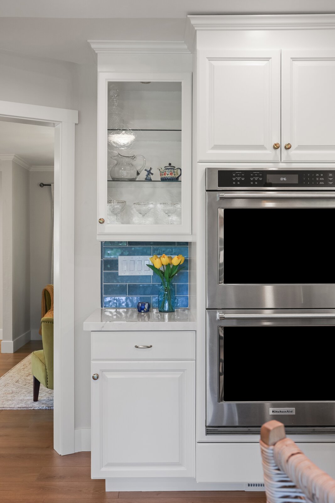 Kitchen remodel in Sacramento, CA with double wall oven, glass front cabinet, and blue tile backsplash