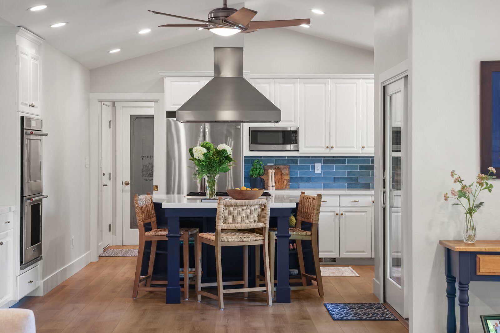 Kitchen remodel in Sacramento, CA with navy blue island and woven counter stools