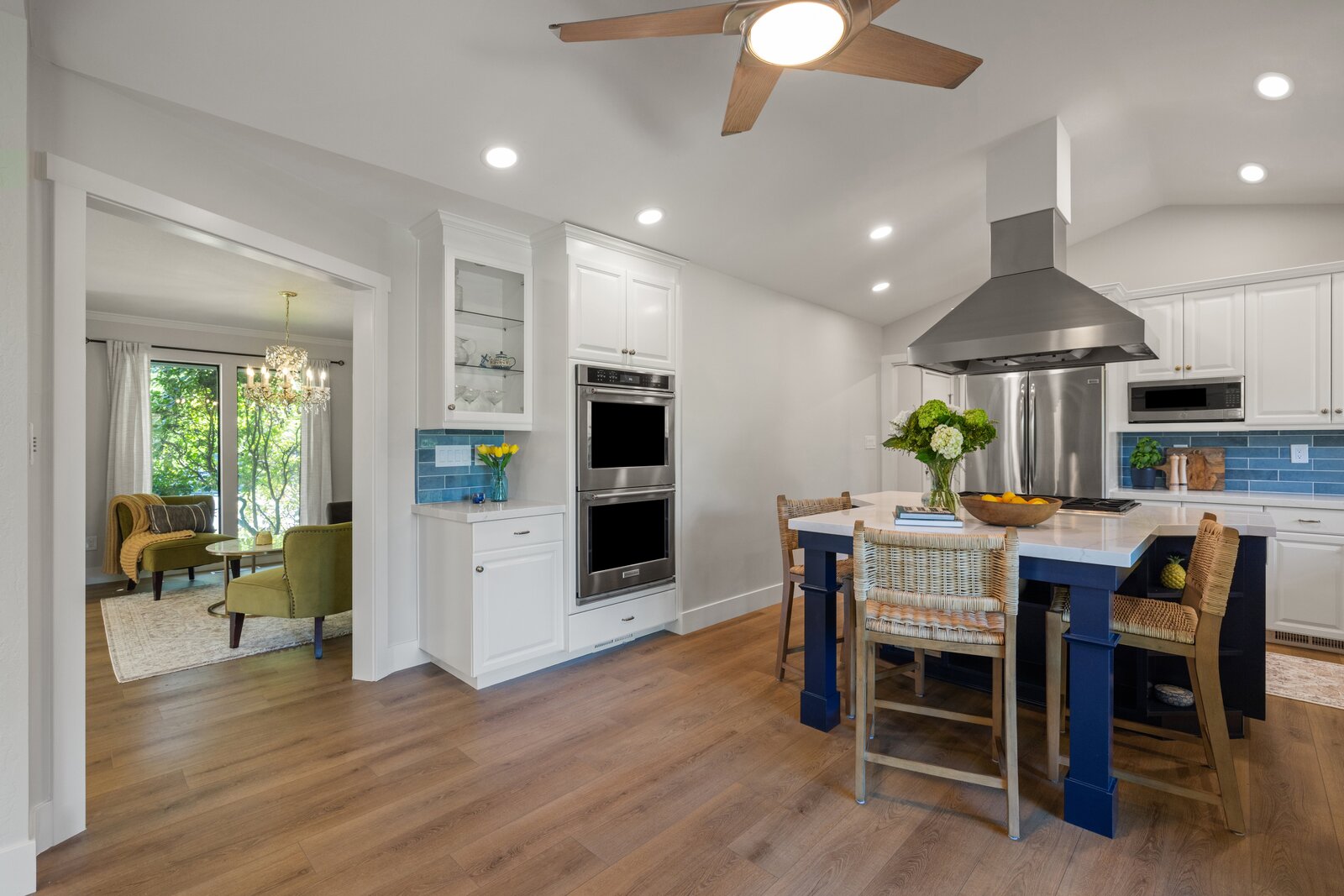 Kitchen remodel in Sacramento, CA with navy island, gold faucet, and blue subway tile