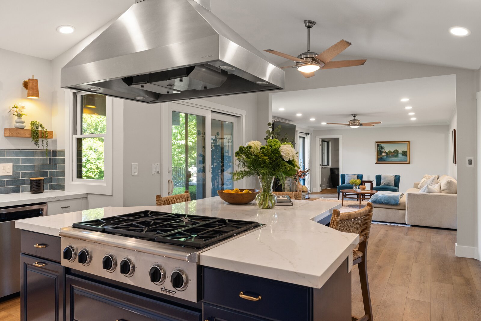Kitchen remodel in Sacramento, CA with navy island, stainless range hood, and open living room view Kitchen remodel in Sacramento, CA with navy island, stainless range hood, and open living room view