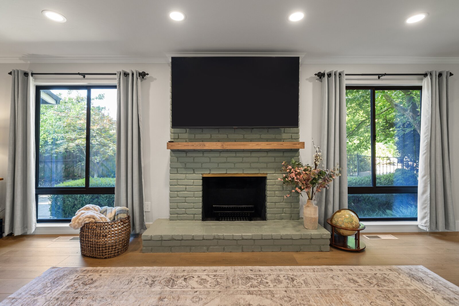 Living room remodel in Sacramento, CA featuring painted brick fireplace with wood mantel