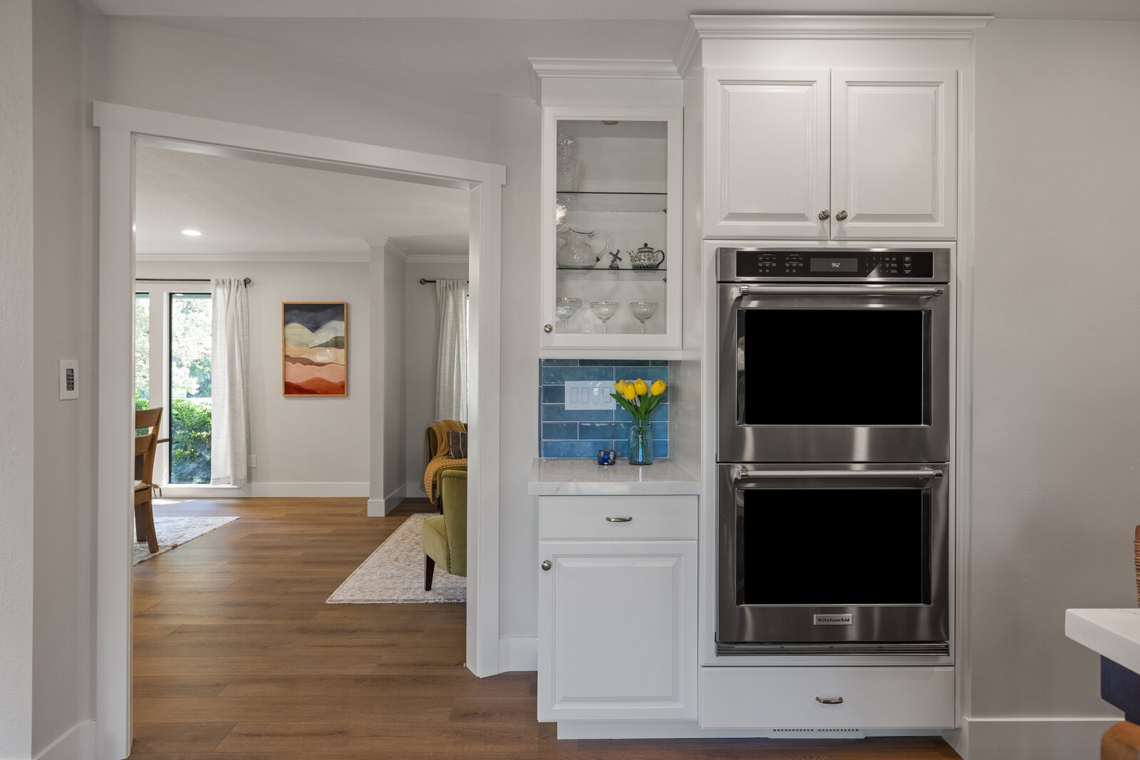 Open concept kitchen remodel in Sacramento, CA with navy island, double oven, and living room view