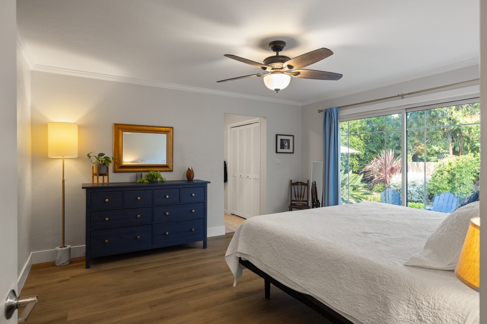 Primary bedroom remodel in Sacramento, CA with navy dresser and gold framed mirror Primary bedroom remodel in Sacramento, CA with navy dresser and gold framed mirror