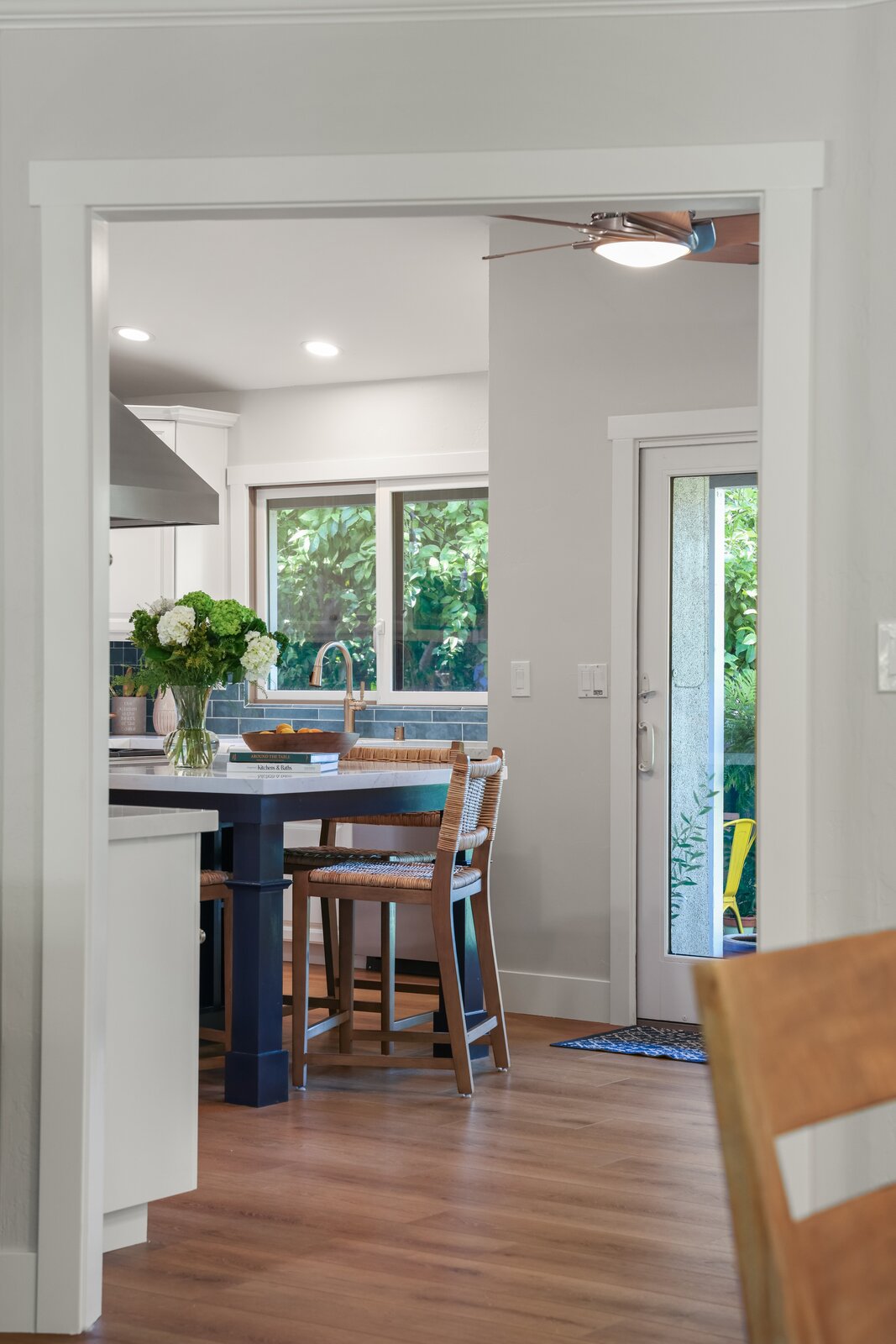 Remodeled hallway in Sacramento, CA with wood flooring and view into kitchen island