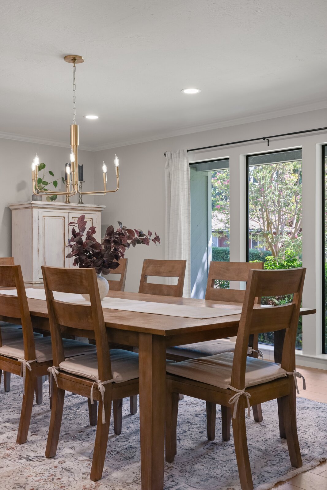 Sacramento area dining room with wood table, brass chandelier, and framed artwork