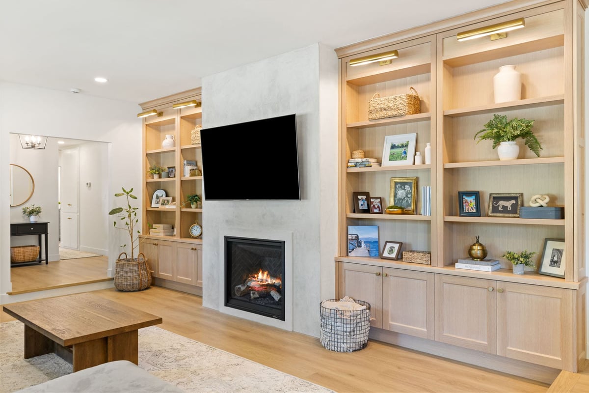 Living room in Sacramento by H&H Builds with light wood built-ins, fireplace, and flat-screen TV