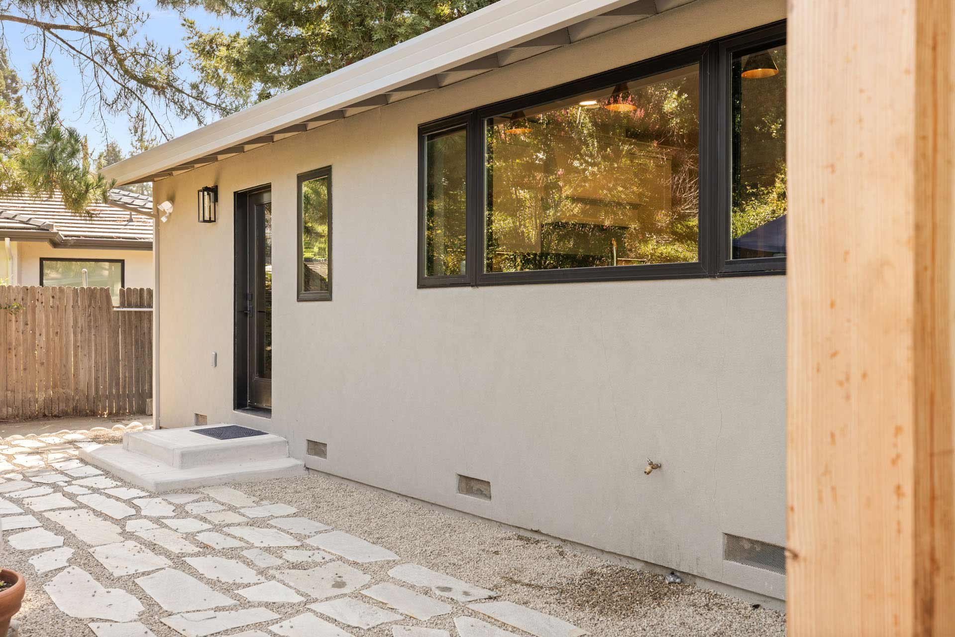 Modern Sacramento exterior by H&H Builds with smooth stucco, black trim windows, and stone walkway