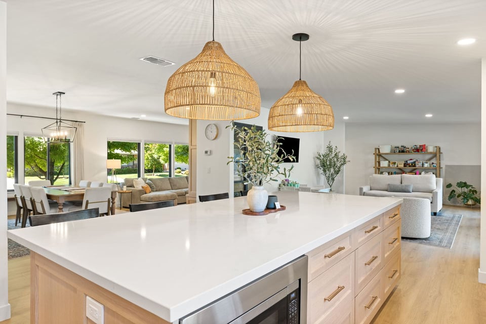 Open-concept kitchen and living space in Sacramento by H&H Builds with woven pendant lights and white island