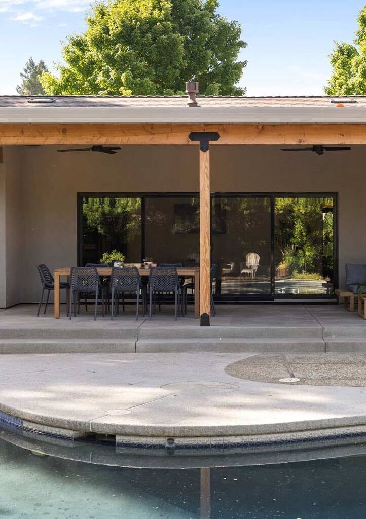 Sacramento backyard by H&H Builds showcasing covered patio, pool, and outdoor dining setup