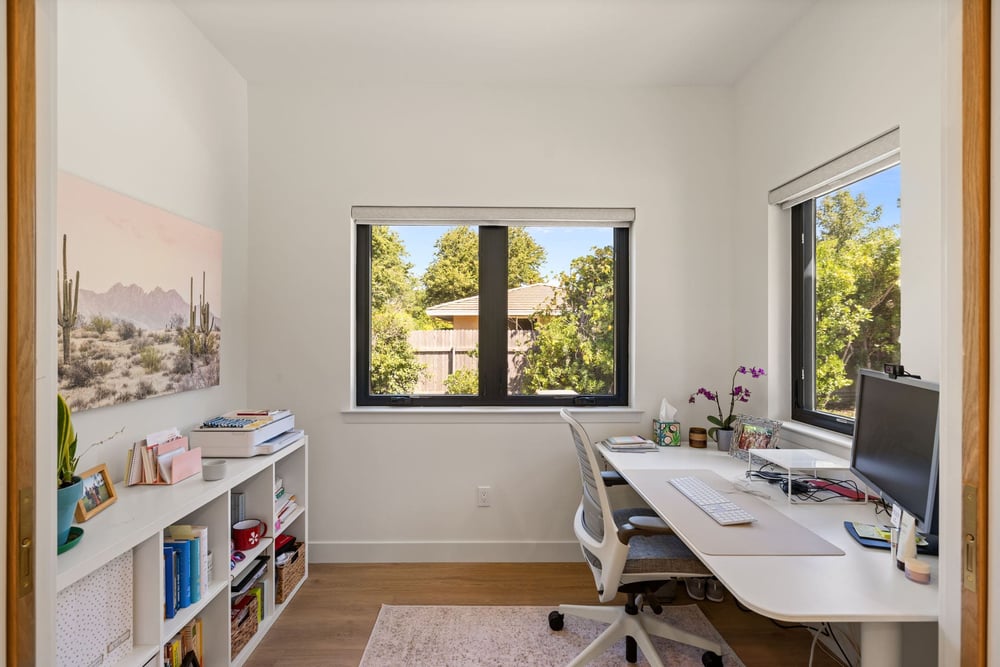 Small home office by in Sacramento with corner desk, open shelving, and window views