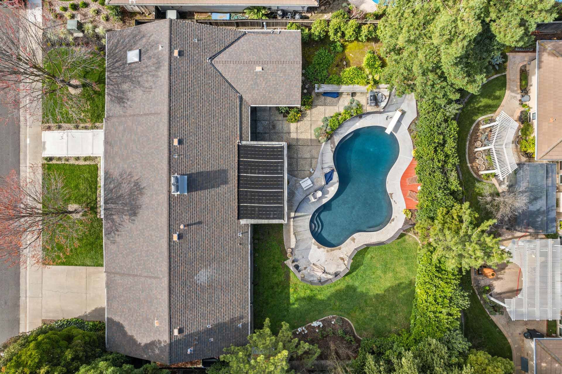 BEFORE aerial view of Sacramento home by H&H Builds with kidney-shaped pool, solar panels, and lush backyard landscaping