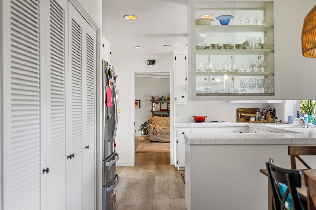BEFORE bright kitchen in Sacramento with white cabinets, wood floors, and cozy sitting room
