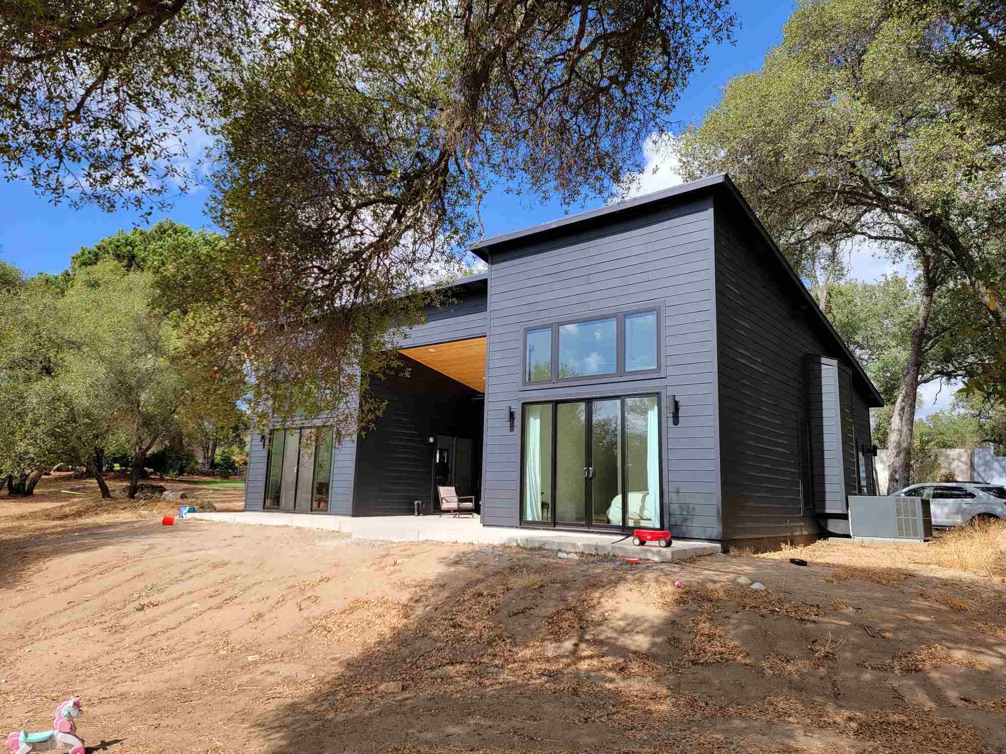 Side view of a modern black custom home with expansive windows in Sacramento, CA by H&H Builds