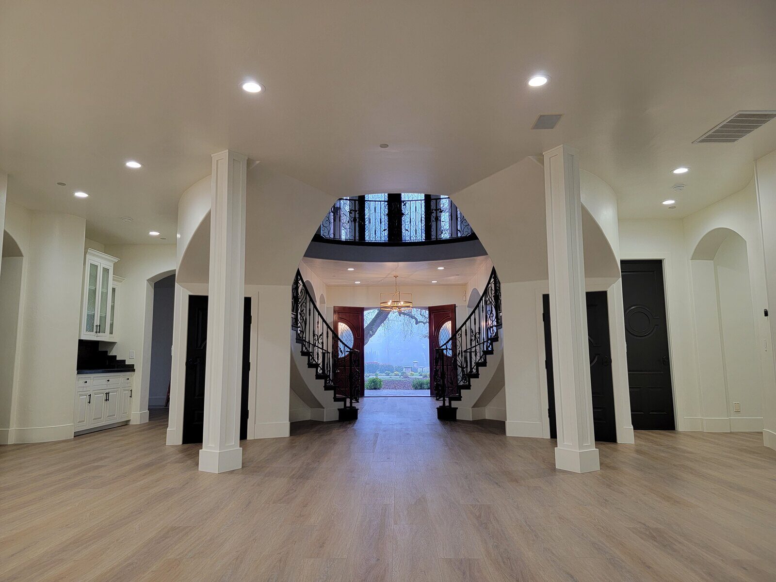 Grand entrance with custom dual staircases and natural light in a remodeled home by H&H Builds, Sacramento, CA