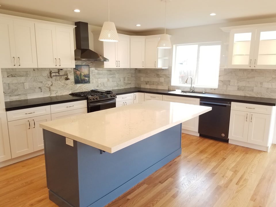Modern kitchen remodel with white cabinetry, a black island, and marble backsplash by H&H Builds in Sacramento, CA
