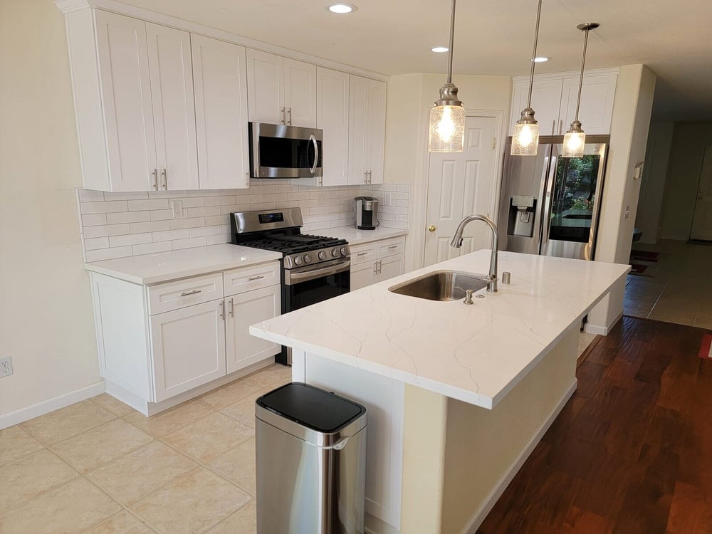 Modern kitchen remodel with white cabinetry, stainless steel appliances, and pendant lighting in Sacramento, CA by H&H Builds