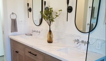 Remodeled bathroom with dual sinks, wooden cabinetry, and modern oval mirrors by H&H Builds in Sacramento, CA