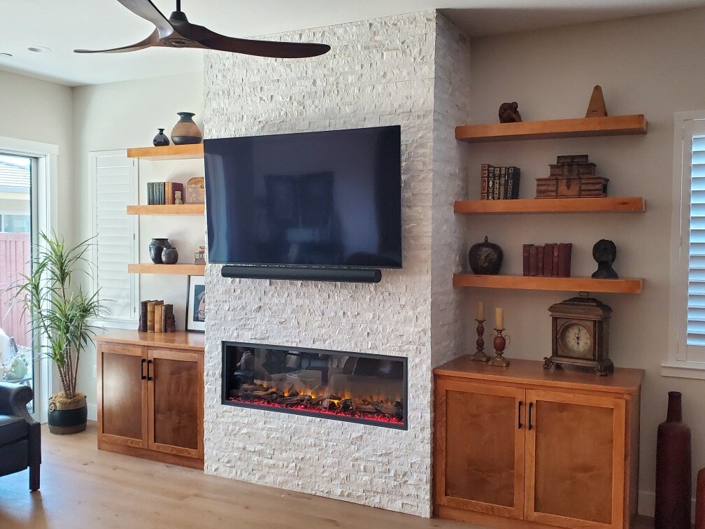 Renovated living room with natural wood cabinets, decorative shelving, and a stone fireplace by H&H Builds, Sacramento, CA Renovated living room with natural wood cabinets, decorative shelving, and a stone fireplace by H&H Builds, Sacramento, CA