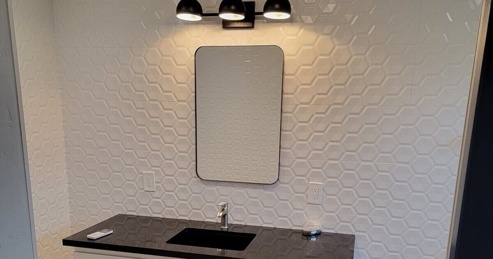 Bathroom remodel with custom white vanity, black countertop, and hexagon tile flooring by H&H Builds in Sacramento, CA