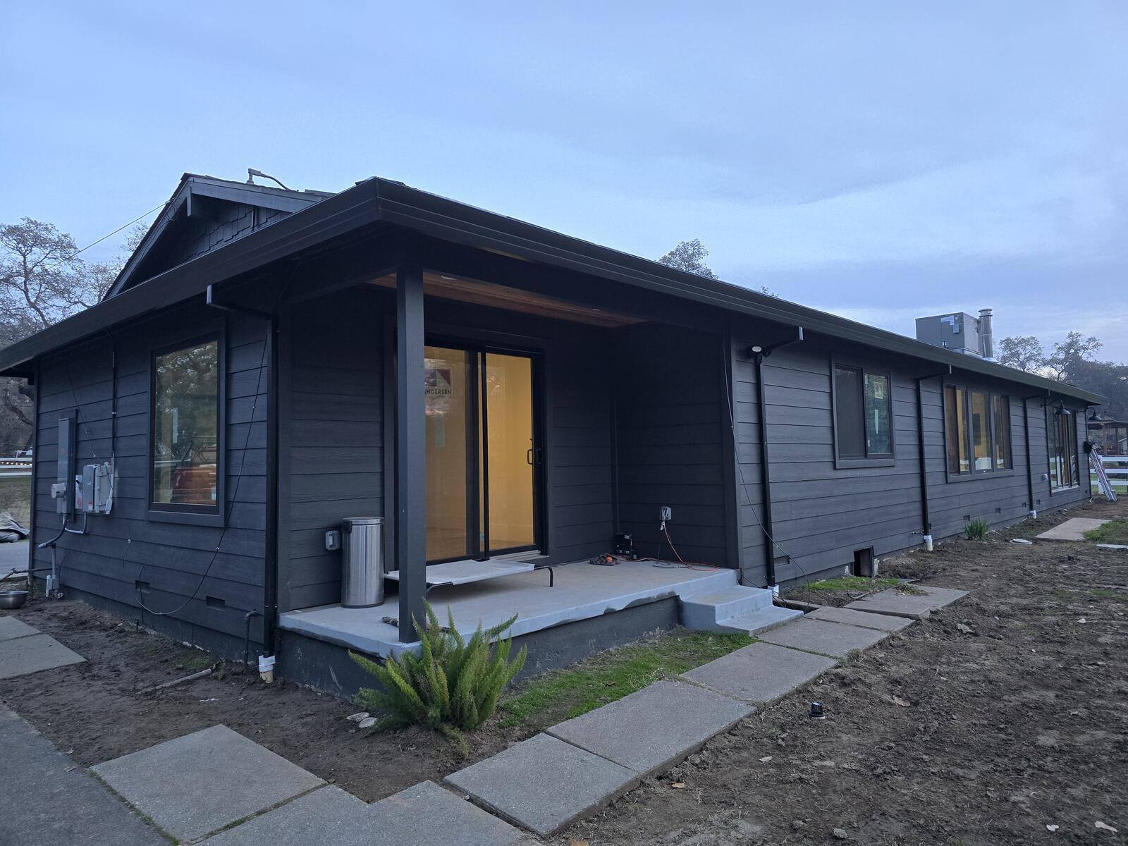 Close-up view of a remodeled home’s modern sliding door and black siding, part of an H&H Builds project in Sacramento, CA