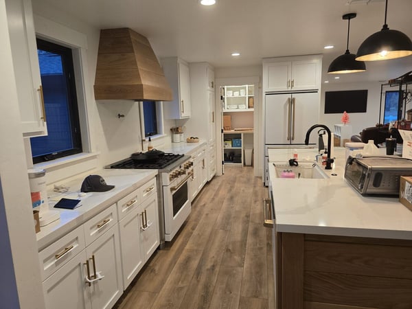 Full view of remodeled kitchen with white cabinets, large island, and modern lighting fixtures by H&H Builds in Sacramento, CA