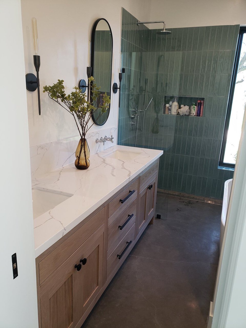 Modern bathroom remodel with a green tiled shower, wooden vanity, and sleek decor by H&H Builds in Sacramento, CA