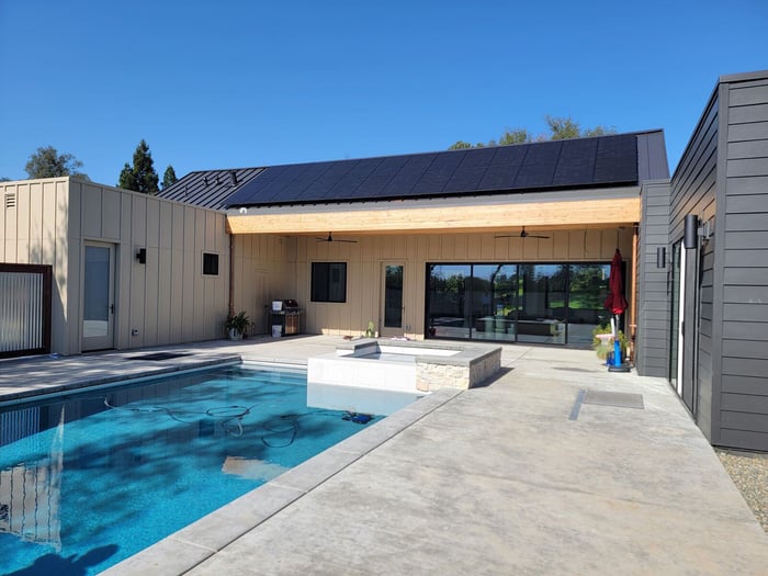 Modern pool and patio remodel featuring a sleek spa, solar-paneled roof, and spacious outdoor area by H&H Builds in Sacramento, CA Modern pool and patio remodel featuring a sleek spa, solar-paneled roof, and spacious outdoor area by H&H Builds in Sacramento, CA
