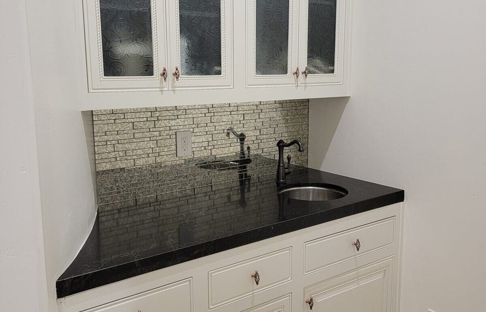 Small kitchen nook with custom white cabinetry and black countertop by H&H Builds in Sacramento, CA