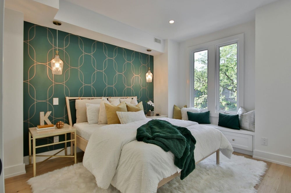 Contemporary bedroom remodel with a green accent wall, cozy white bedding, and modern lighting by H&H Builds in Sacramento, CA