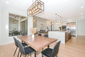 Modern dining room with a minimalist wooden table, chic lighting, and open-concept layout by H&H Builds in Sacramento, CA