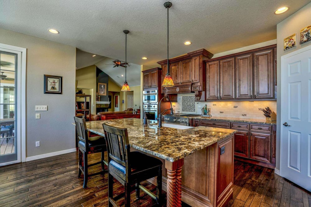 Rustic kitchen remodel with dark wood cabinets, granite countertops, and pendant lighting by H&H Builds in Sacramento, CA
