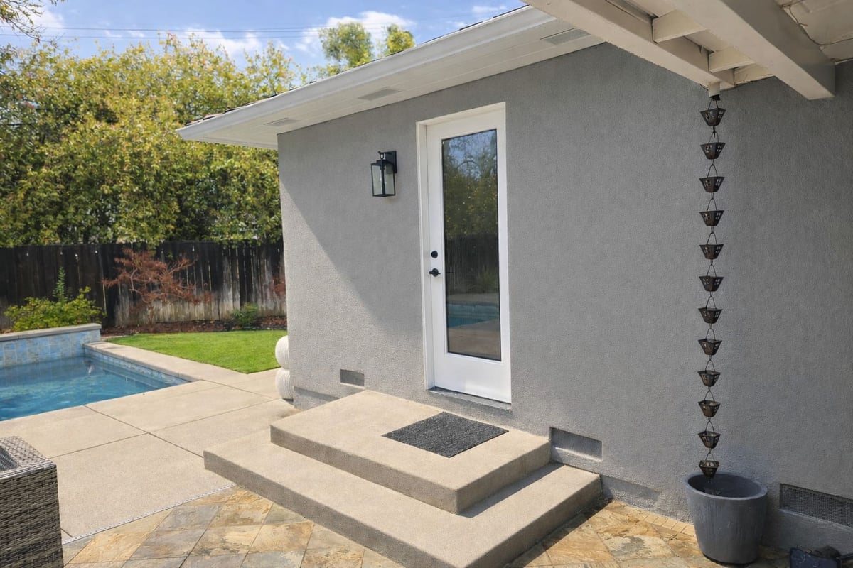 Modern backyard renovation with a pool, patio, and gray guest house addition in Sacramento, CA, by H&amp;H Builds