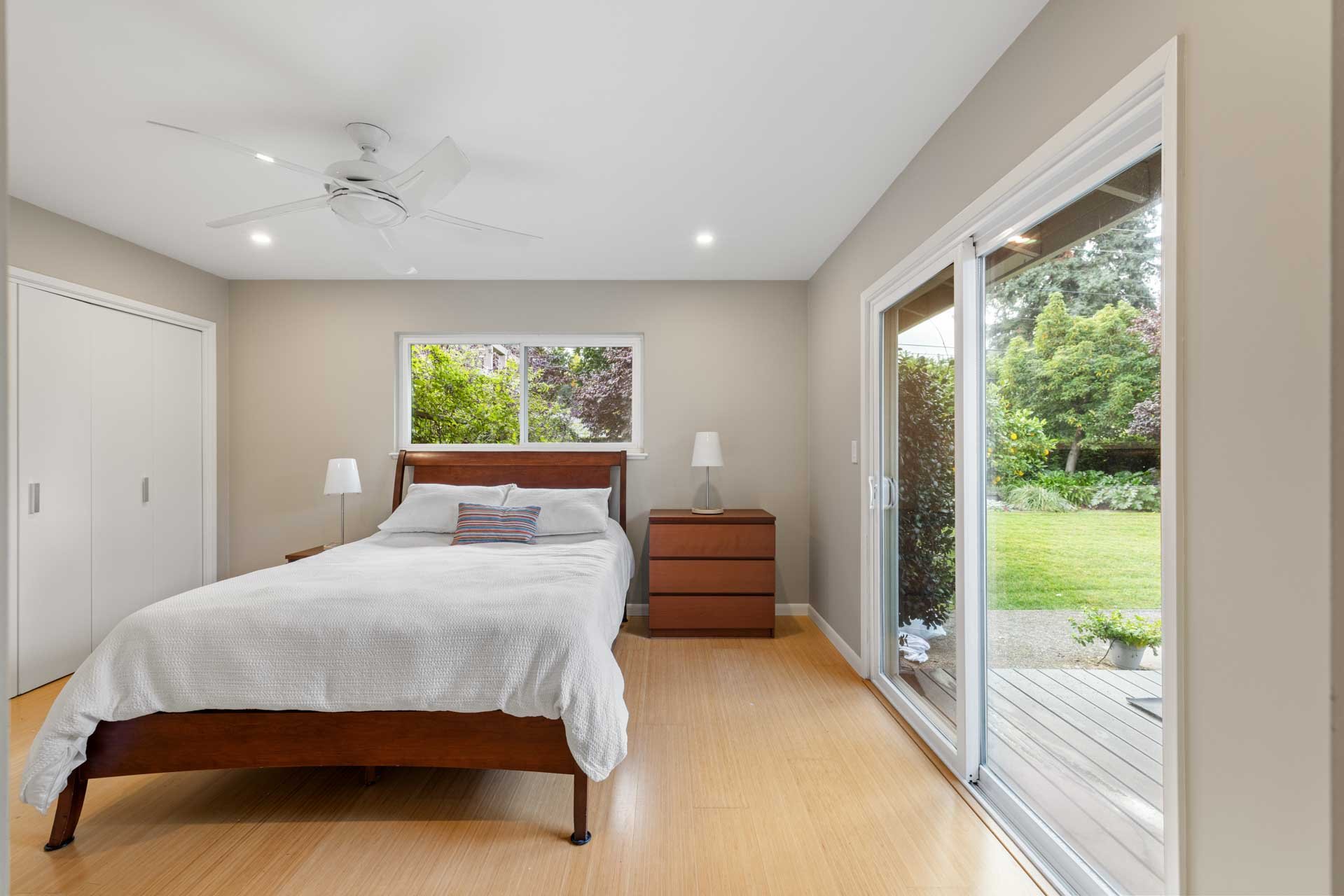 Bright Sacramento bedroom with backyard access, large window, and simple modern furnishings