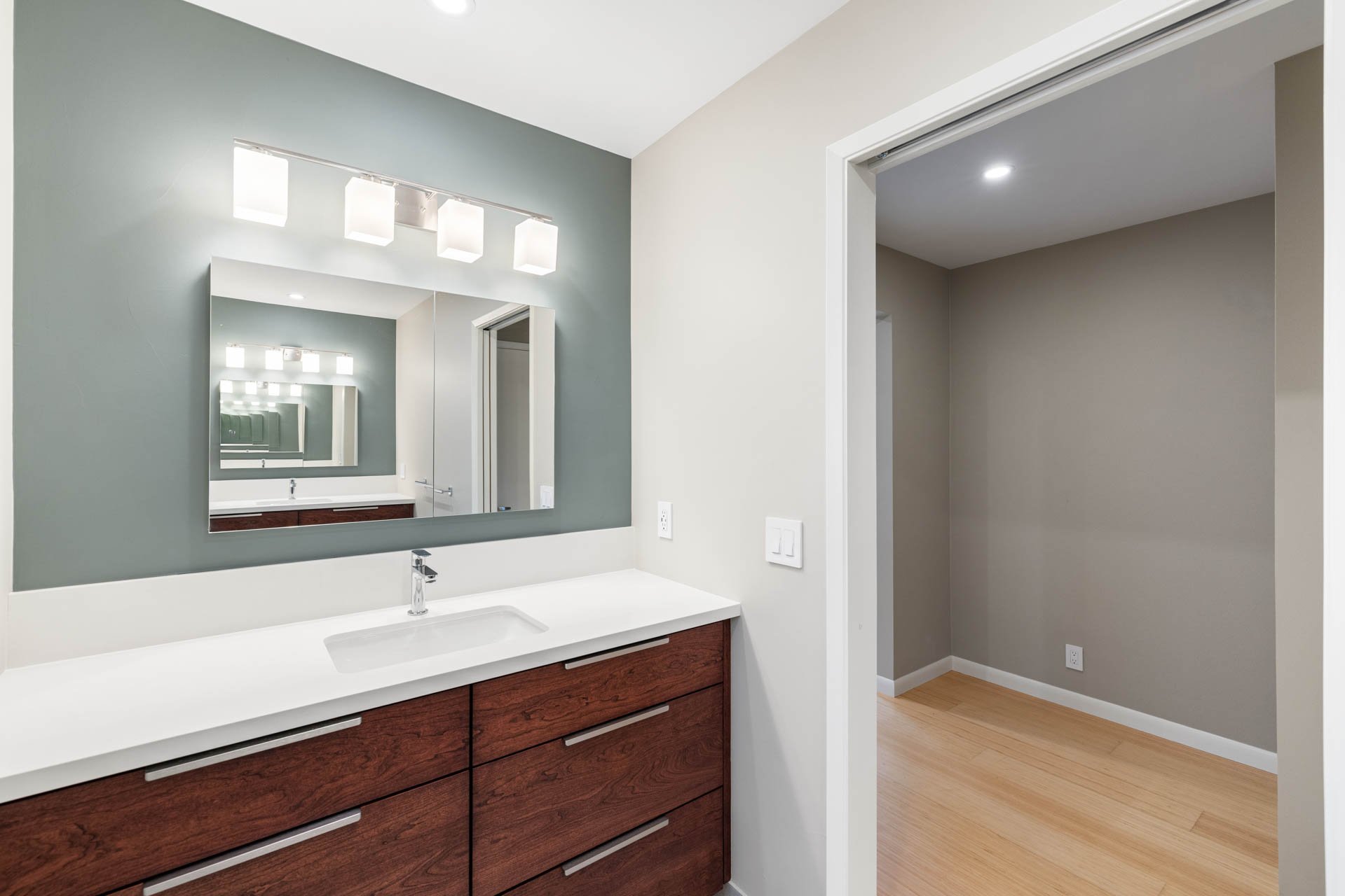 Modern vanity with white countertop and wood drawers in Sacramento bathroom