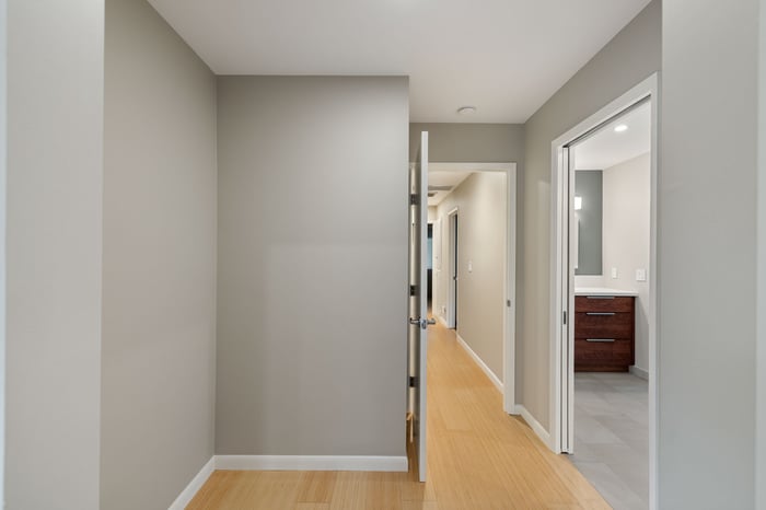 Neutral-toned hallway in a Sacramento home with bamboo flooring and partial view of a modern bathroom vanity
