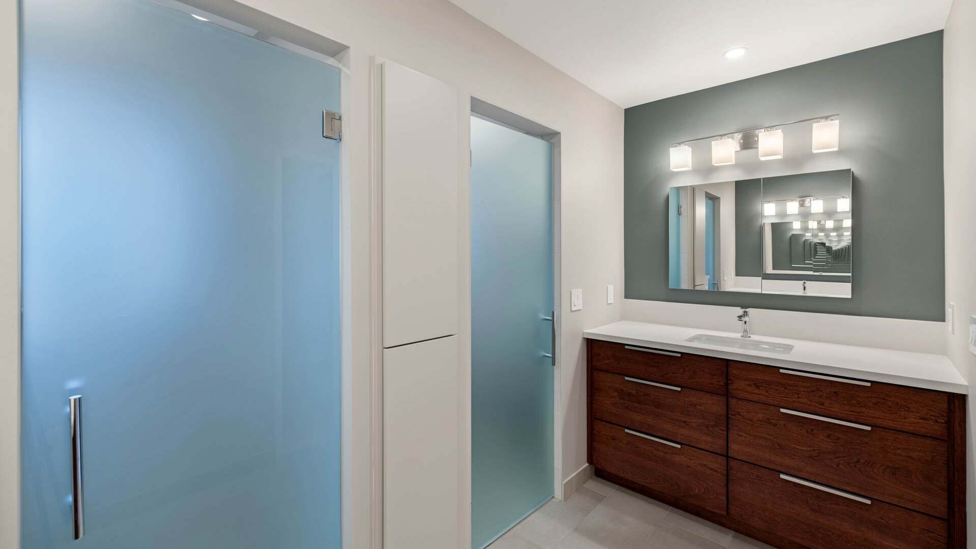 Updated Sacramento bathroom with modern vanity, white countertop, and frosted glass shower and door