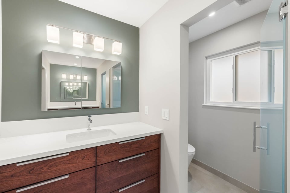 Newly remodeled Sacramento bathroom with frosted glass door leading to private toilet room