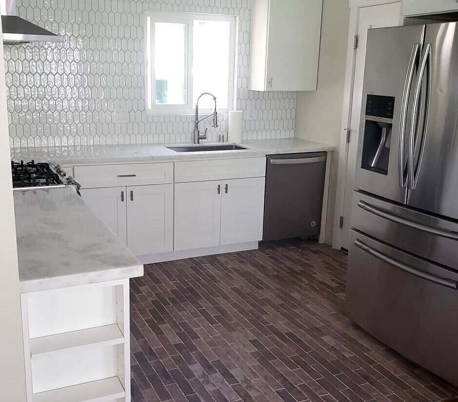 Remodeled kitchen with white cabinets, stainless steel appliances, and brick flooring by H&H Builds in Sacramento, CA