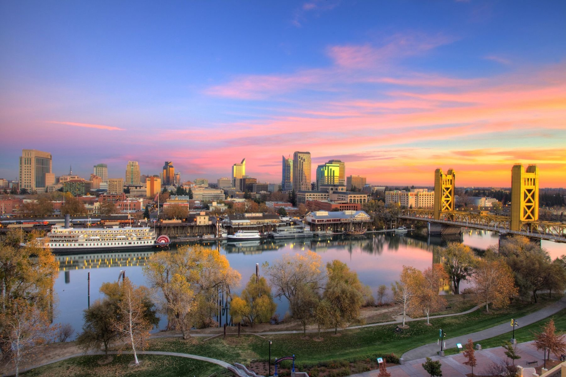 Sacramento skyline at sunset with Tower Bridge and riverfront reflecting colorful sky Sacramento skyline at sunset with Tower Bridge and riverfront reflecting colorful sky