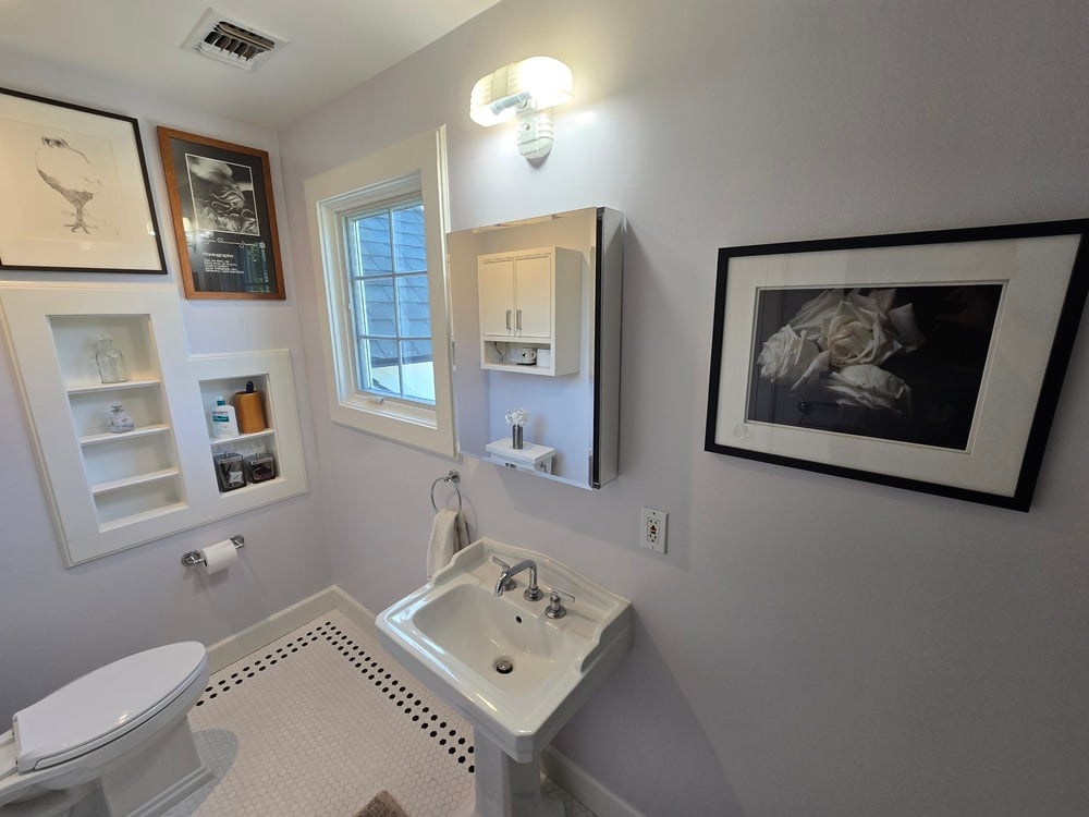 Vintage inspired bathroom with pedestal sink and built in storage