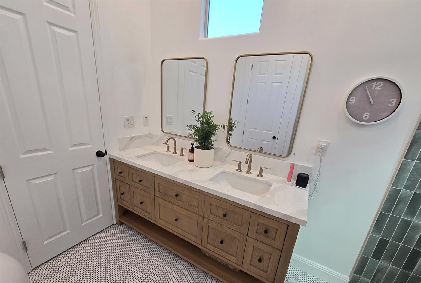 Sacramento area bathroom with wood vanity, double sinks, gold fixtures, and modern mirrors