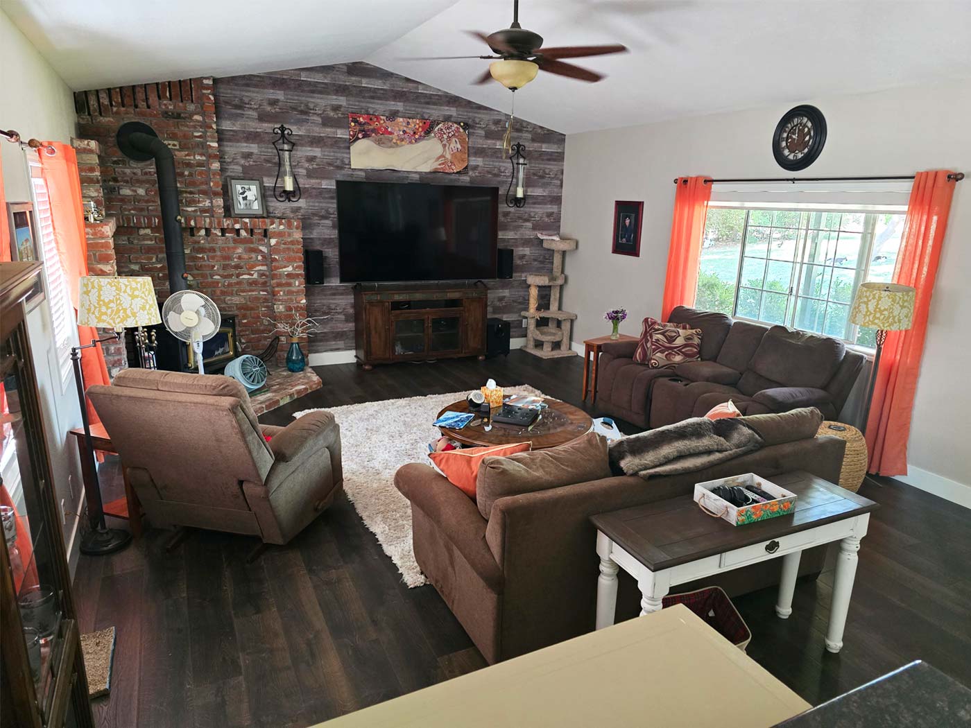 Cozy Sacramento area living room with brick fireplace, sectional sofa, and large window