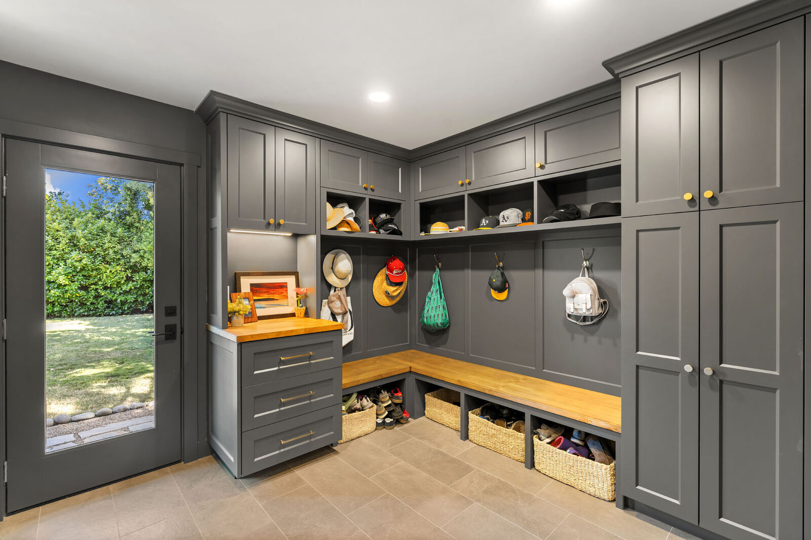 Custom mudroom in Sacramento CA with gray cabinets and wood bench storage